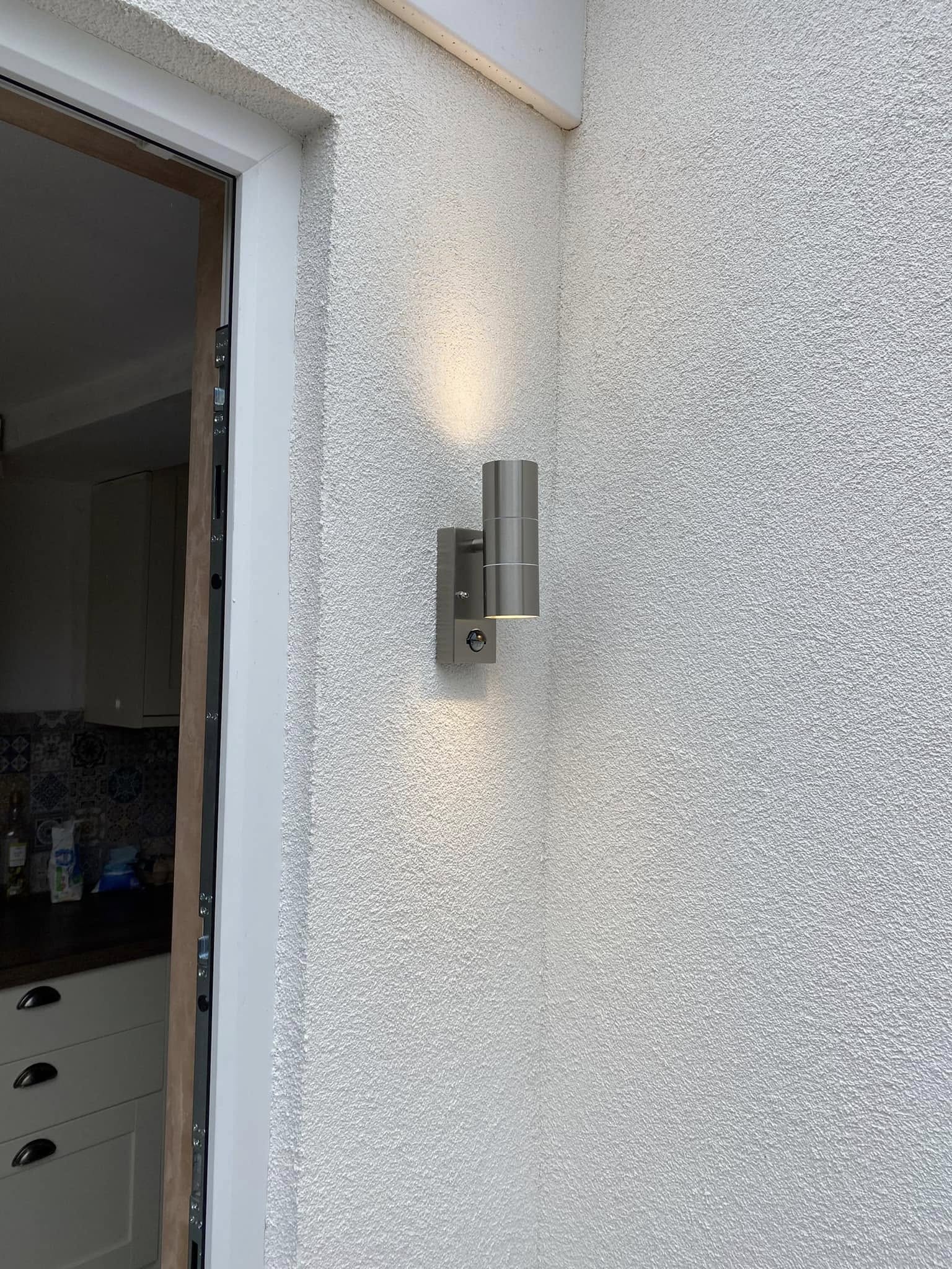 Stainless steel wall light beside a back door