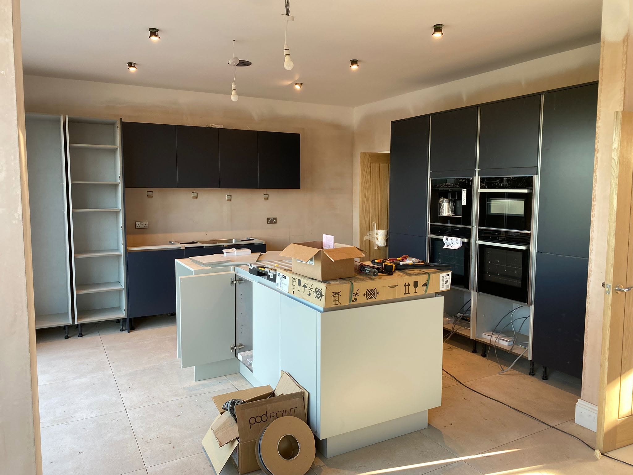 New kitchen being fitted, with downlights and pendant wiring in the ceiling