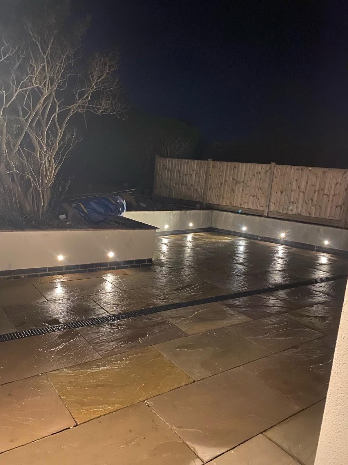 Patio lit at night by recessed lights set into the step